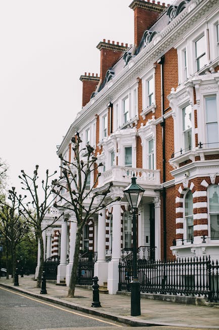 A row of Victorian terraced houses with red brick facades and white decorative architectural details, including ornate window trims, cornices, and balcony railings. Each property features multiple sas